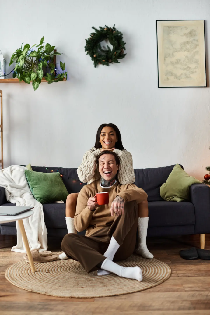 Pareja joven en el sillón riéndose