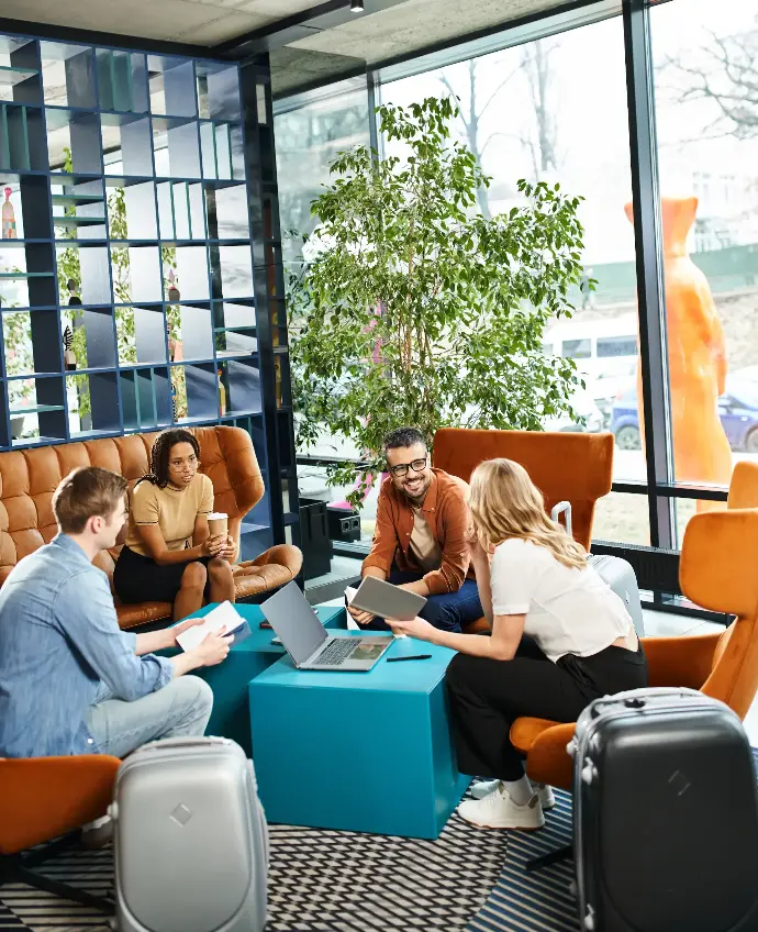 Espacio de coworking con 4 personas sentadas en unos sillones sonriendo