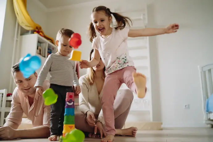 Familia jugando con cubos en su casa con sus dos hijos pequeños