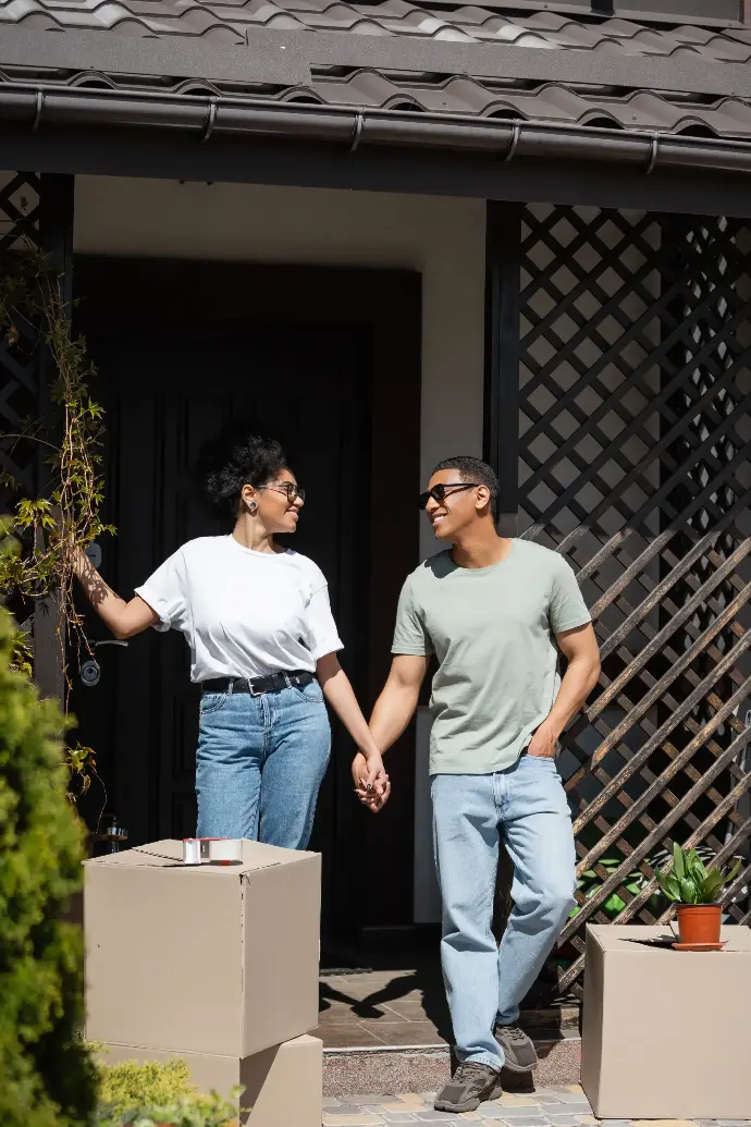 Pareja joven en la entrada de su casa