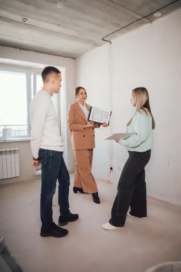 Mujer enseñando un piso a una pareja